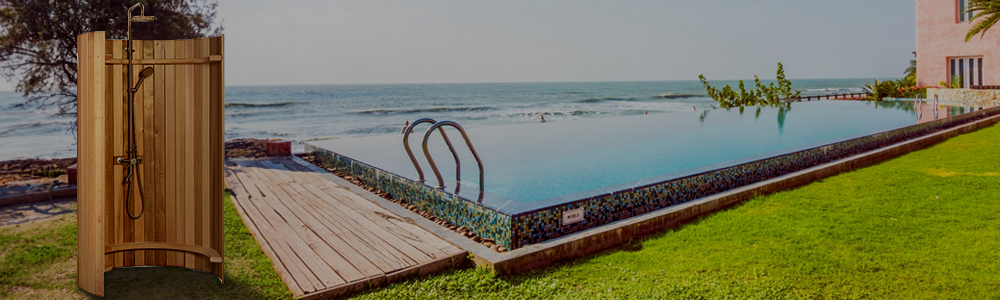 An Almost Heaven outdoor wooden shower stall next to a resort infinity pool overlooking the ocean.