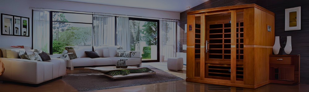 An indoor wooden infrared cabin sauna with a glass door and window panels set in a spacious, modern living room with a white sofa and glass sliding doors leading outside.