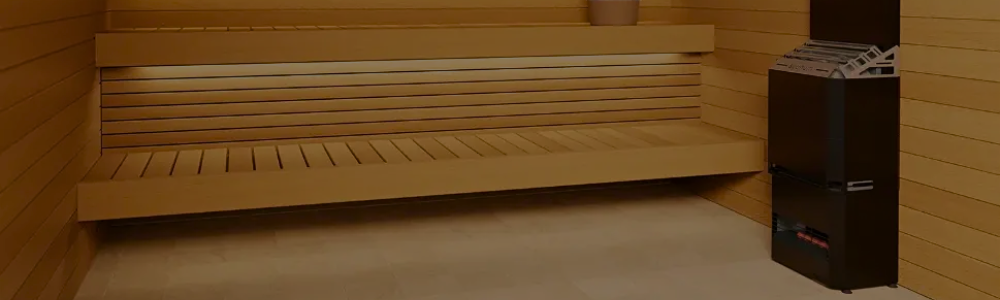 A black Saunum sauna heater next to tiered wooden benches inside a sauna room.
