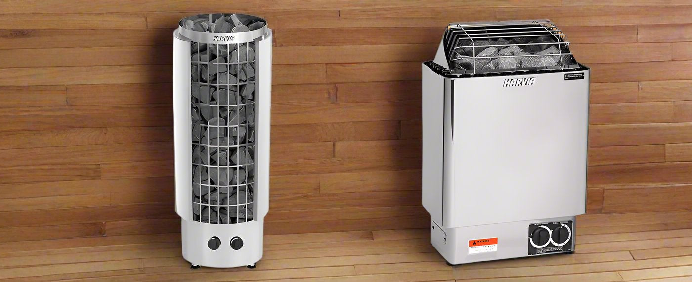 stainless steel Harvia electric sauna heaters filled with dark rocks, displayed side-by-side against a warm, horizontal wooden plank wall.