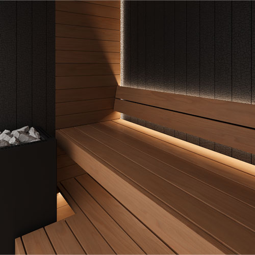 A modern wooden sauna interior with tiered wooden benches, warm ambient under-lighting, dark textured wall panels, and a sauna heater filled with rocks.