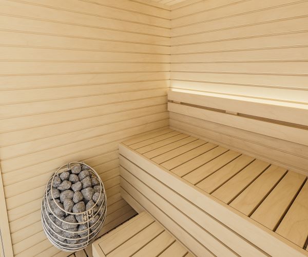 Wooden sauna with a bench and a sauna heater with stones.