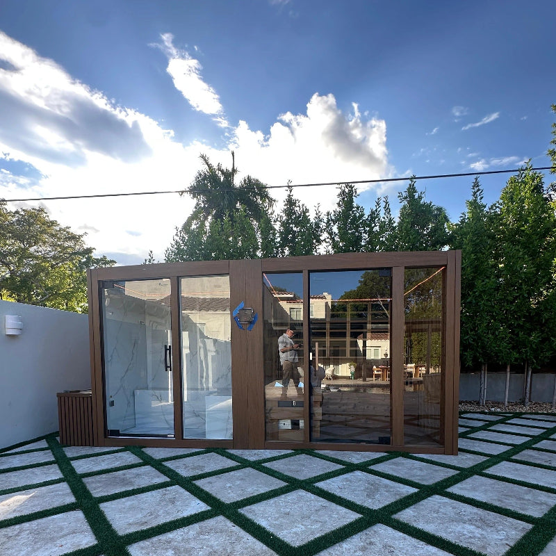Modern outdoor structure with glass walls in a garden setting