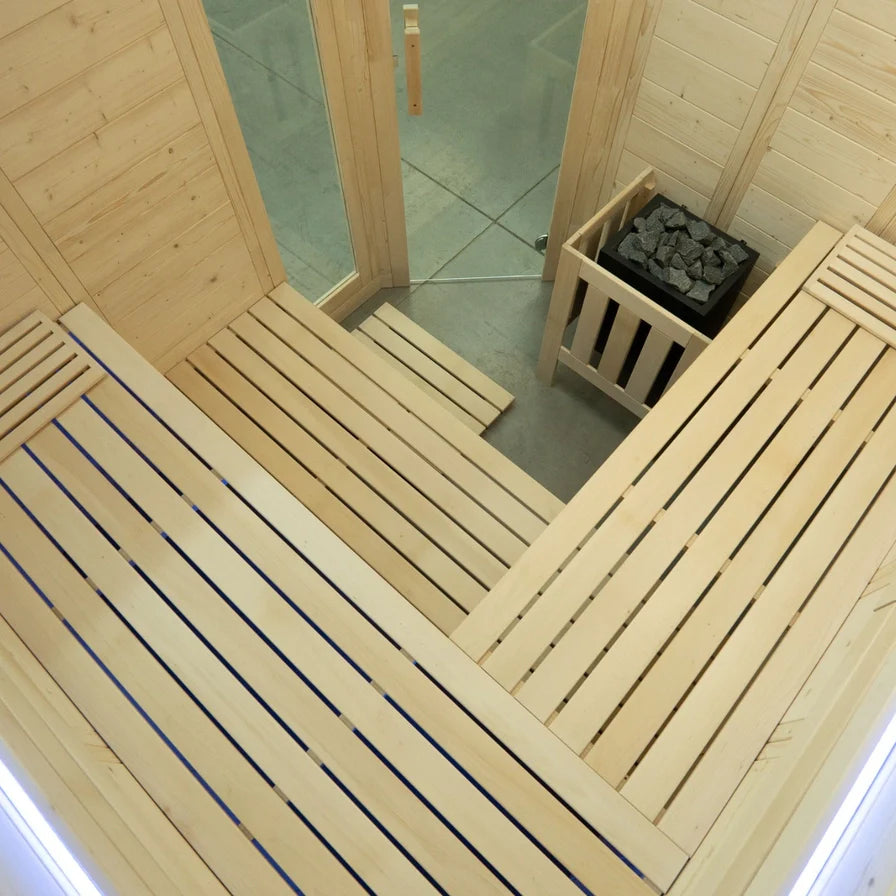 Wooden sauna interior with benches and a glass door.
