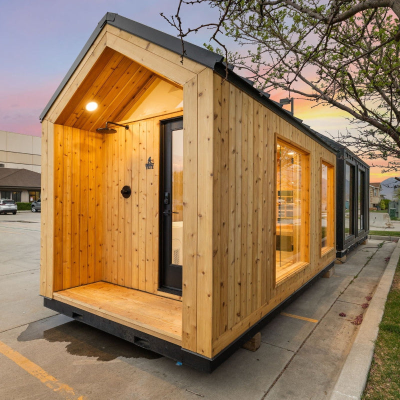 Sweaty Yeti 4-6 Person Outdoor Sauna & Cold Plunge Cabin in right-side view with trees in the background.
