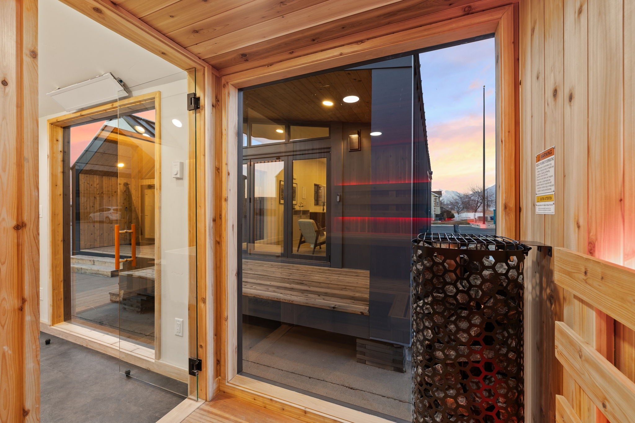 Wooden interior of a modern home with large glass door and wall.