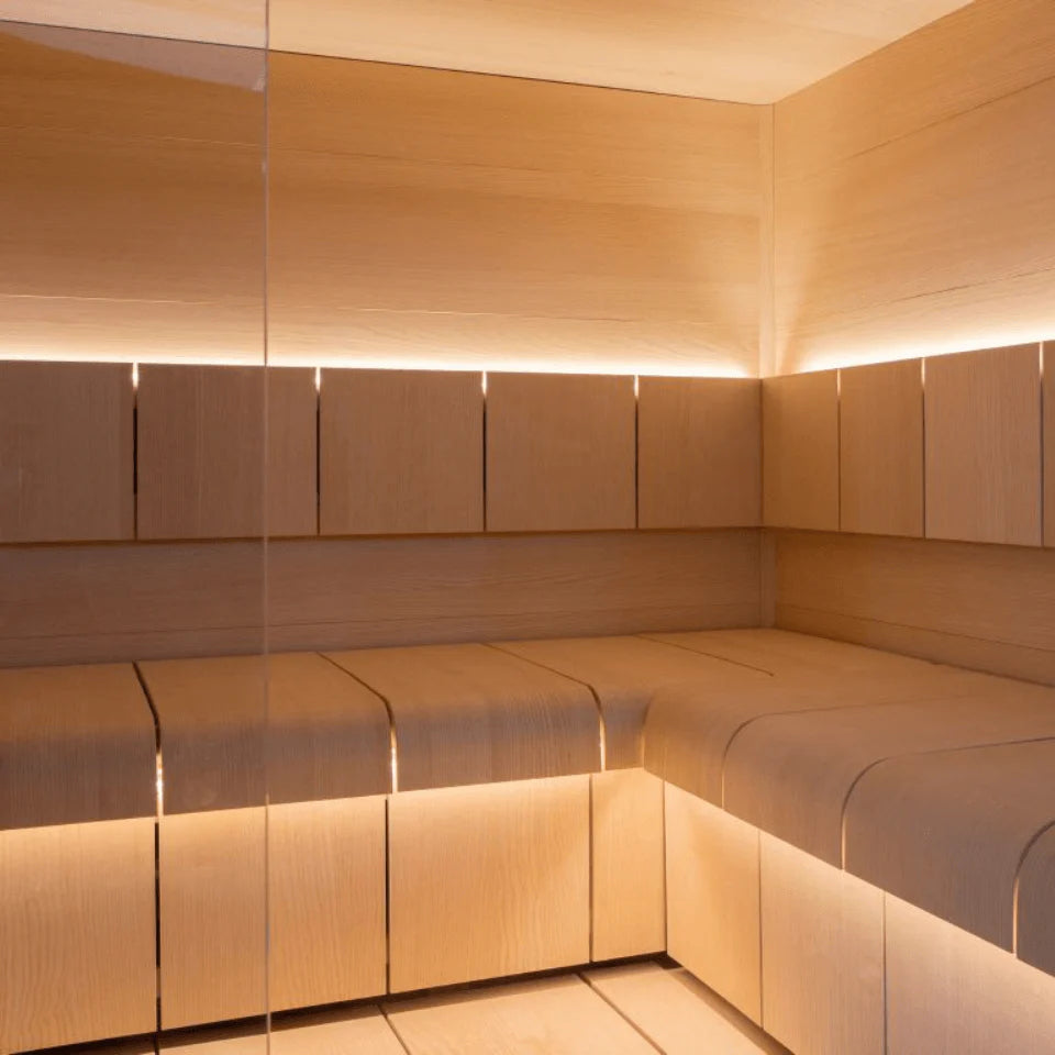 Wooden sauna interior with benches and illuminated panels.