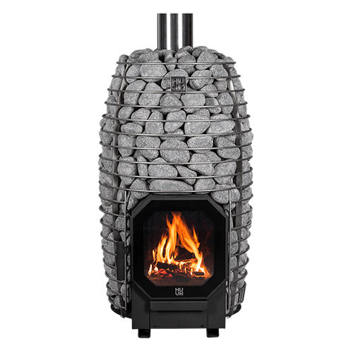 Front view of the HUUM HIVE Flow stove loaded with stones, fire lit