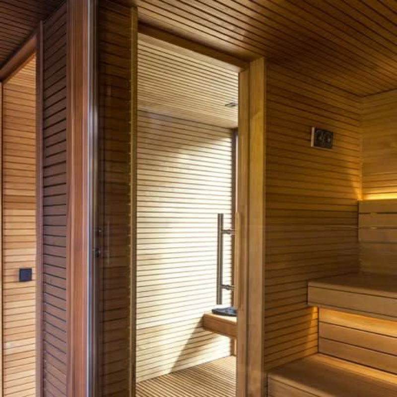 Wooden sauna interior with benches and a door.