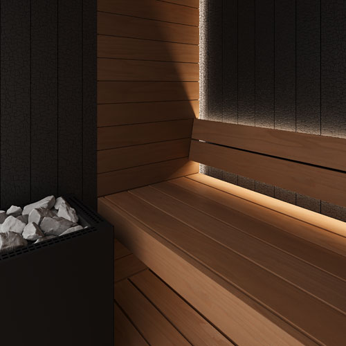 A modern wooden sauna interior with wooden benches, warm ambient lighting along the walls, dark textured wall panels, and a sauna heater filled with white rocks in the lower left.