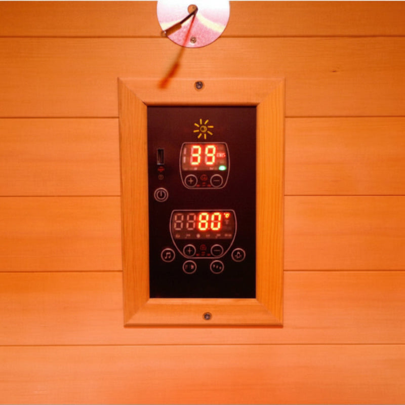 A digital temperature controller panel with LED displays mounted on a wooden sauna wall, showing 39 degrees Celsius and 80 degrees Celsius.