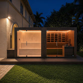 Modern wellness retreat with a glass steam room, traditional sauna, and warm evening illumination.