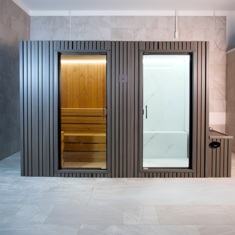 GeyserSteam Vapora Dual Cabin featuring a dark slatted exterior with a traditional wooden dry sauna on the left and a glass-enclosed steam room on the right