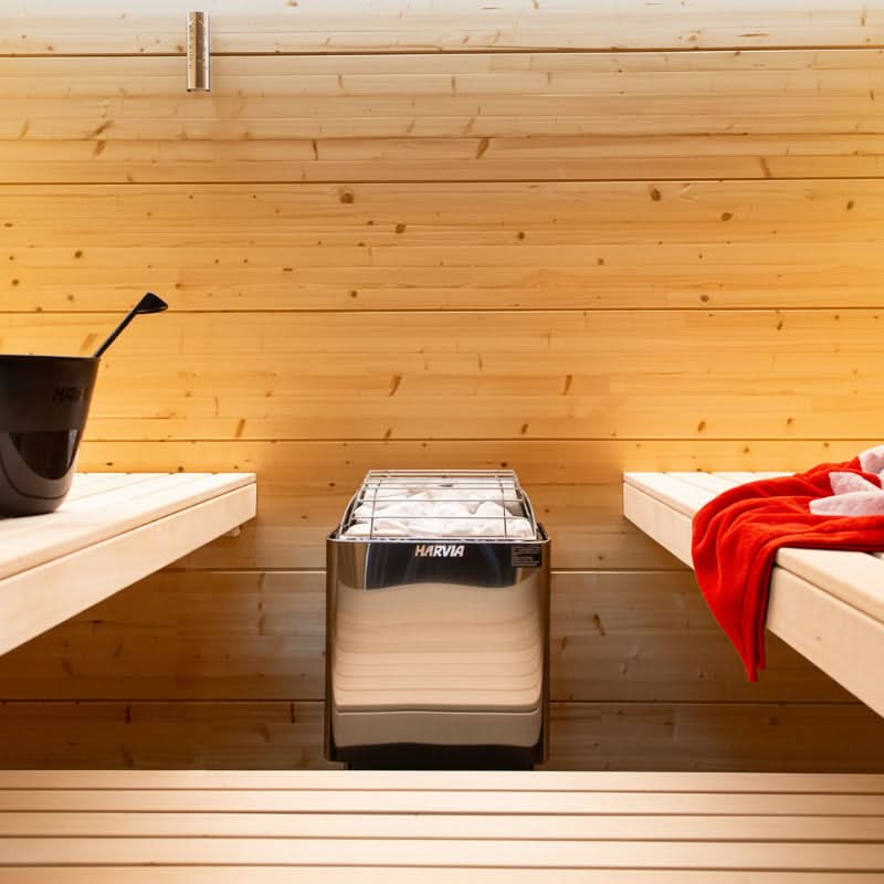 Wooden sauna interior with a Harvia Heater and benches.