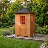 Sunray Eagle A wooden outdoor sauna with a warm brown wood-grain exterior, a black pyramid roof, and a front window with red curtains, shown on a plain white background.