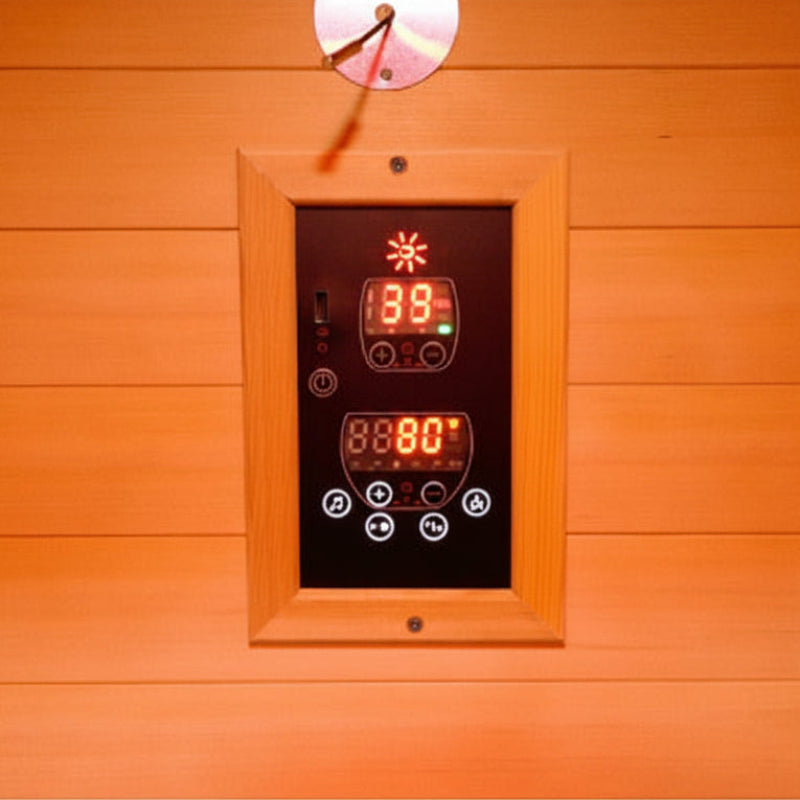 A wooden sauna control panel with digital temperature displays showing 39 degrees Celsius and 80 degrees Celsius, mounted on a wood-paneled wall.