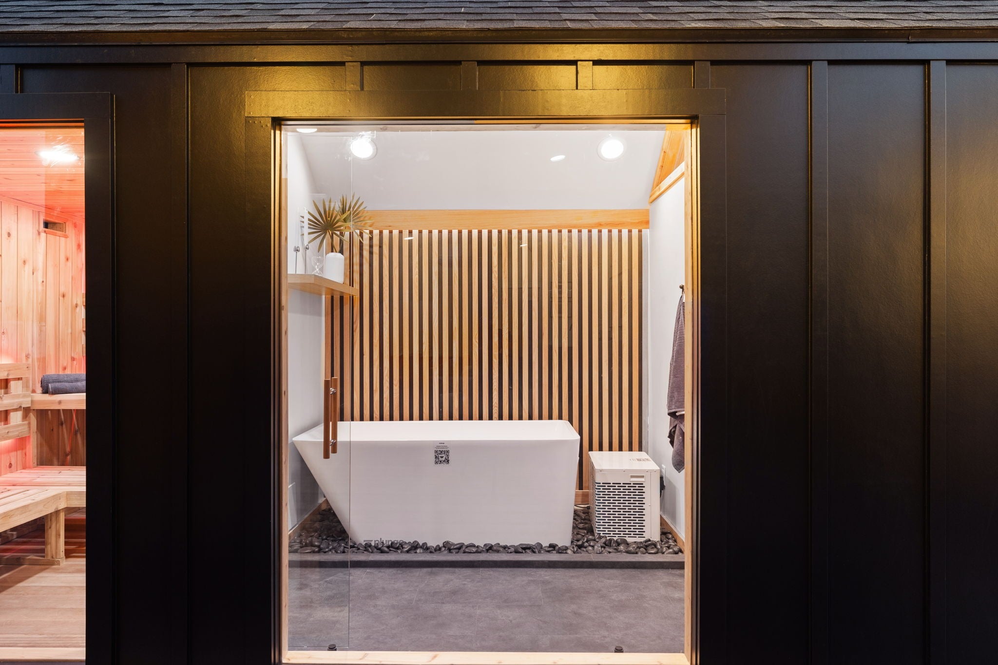 Sweaty Yeti 4-6 Person Outdoor Sauna & Cold Plunge Cabin through a glass window.