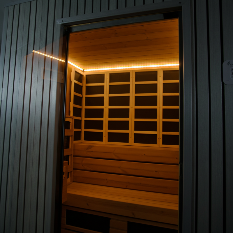 GeyserSteam Saunas Modern wood-paneled home sauna cabin with tiered benches and warm LED strip lighting. 